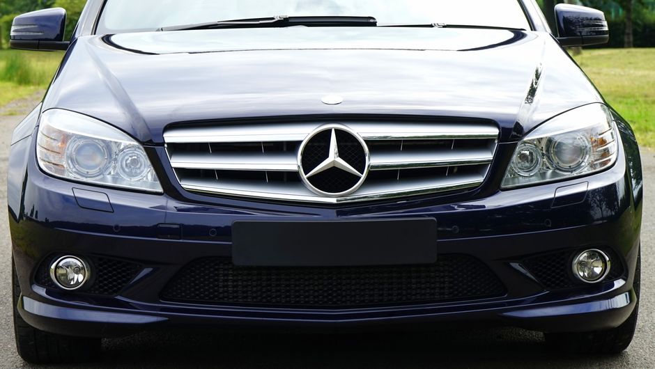 Stylish front view of a luxury blue sedan with a prominent emblem, highlighting modern automotive design.